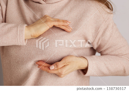 Woman Performing Breast Self Examination in Pink Sweater Woman Performing Breast Self Examination in Pink Sweater 138730317