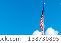 American flag waving proudly against a bright blue sky with fluffy white clouds, symbolizing freedom and national pride in a vibrant atmosphere 138730895