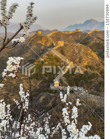 Golden light bathes ancient walls winding through hills 138730994