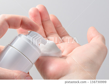 Hands applying foamy soap cleanser from pump bottle Hands applying foamy soap cleanser from pump bottle 138730999