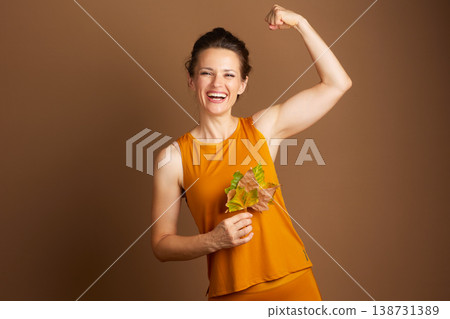 Strong Woman Flexing with Autumn Leaves Strong Woman Flexing with Autumn Leaves 138731389