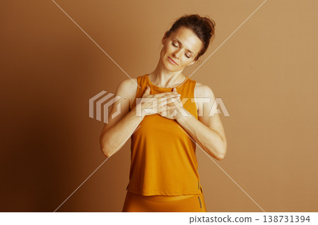 Inner Peace: Woman in Orange Mindful Pose Inner Peace: Woman in Orange Mindful Pose 138731394