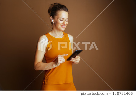 Woman with Earbuds Browsing Smartphone Woman with Earbuds Browsing Smartphone 138731406