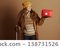 Woman Leaning on Ski Pole with First Aid Kit 138731526