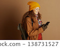 Smiling Hiker with Backpack Using Smartphone 138731527
