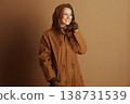 Cheerful Woman in Autumn Jacket, Hand on Face 138731539