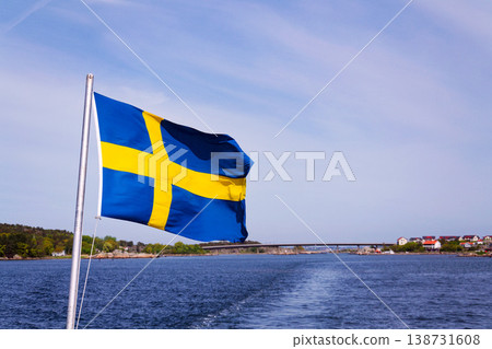 Swedish flag on ferry near bridge between Styrso and Donso islands of Gothenburg archipelago, Gothenburg Minucipality, Vastra Gotaland County, Sweden, sunny day 138731608