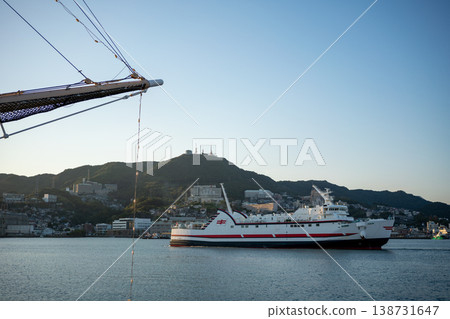 Ships sailing in the harbor and a town with mountain ranges 138731647