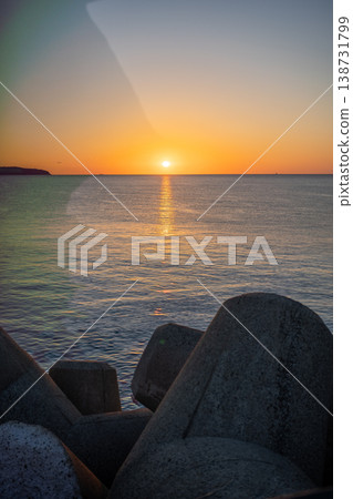 Sunset over the sea and breakwater blocks Sunset over the sea and breakwater blocks 138731799