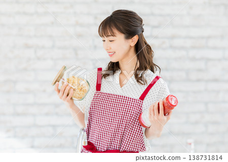 煮麵食在廚房裡的年輕女子 煮麵食在廚房裡的年輕女子 138731814