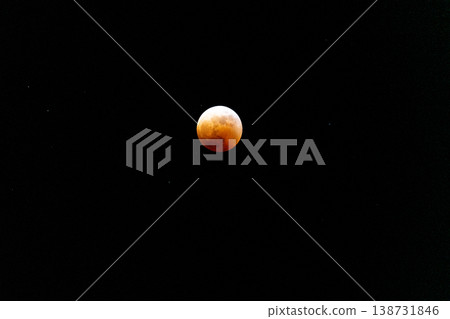 A red moon floating in the night sky during a total lunar eclipse. A red moon floating in the night sky during a total lunar eclipse. 138731846