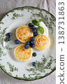 Cheesecakes with blueberries and sour cream lying on vintage plate 138731863
