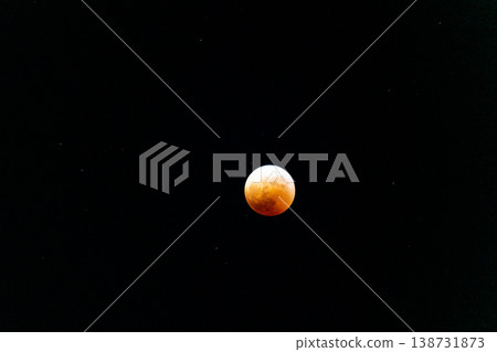 A total lunar eclipse shining in the night sky. A total lunar eclipse shining in the night sky. 138731873
