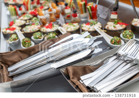 Stainless steel cutlery set with forks and knives on a tray 138731918