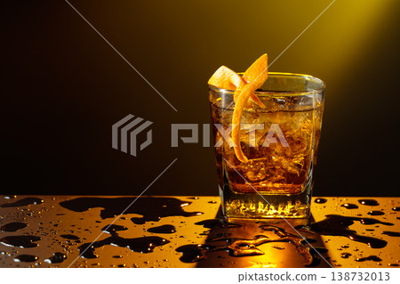 Old fashioned cocktail in a sweating glass on a wet black table. Old fashioned cocktail in a sweating glass on a wet black table. 138732013