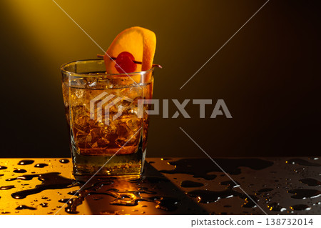 Old fashioned cocktail in a sweating glass on a wet black table. 138732014
