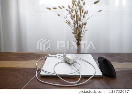 Laptop with charger cable and mouse minimal workspace natural light Laptop with charger cable and mouse minimal workspace natural light 138732087