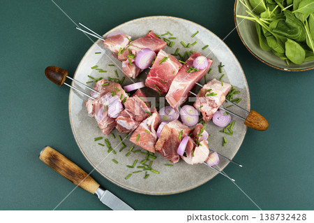 Raw pork skewers with onion and herbs on plate Raw pork skewers with onion and herbs on plate 138732428