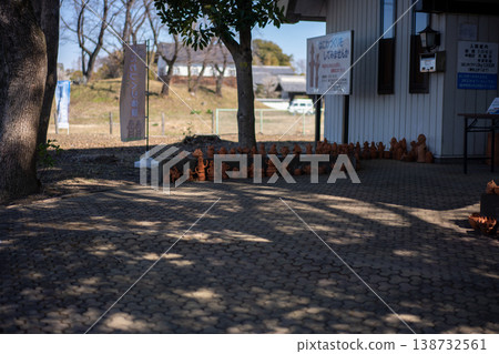 A path lined with Haniwa figures and dappled sunlight filtering through the trees A path lined with Haniwa figures and dappled sunlight filtering through the trees 138732561