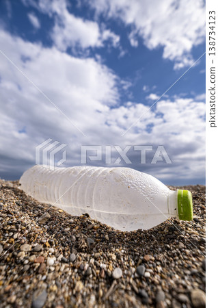 Environmental Pollution Discarded Plastic on Sand. Plastic Waste Bottles on Sandy Beach. Environmental Pollution Discarded Plastic on Sand. Plastic Waste Bottles on Sandy Beach. 138734123