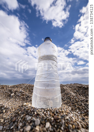 Environmental Pollution Discarded Plastic on Sand. Plastic Waste Bottles on Sandy Beach. Environmental Pollution Discarded Plastic on Sand. Plastic Waste Bottles on Sandy Beach. 138734125