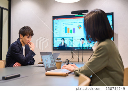 Men and women conducting hybrid meetings with remote members 138734249
