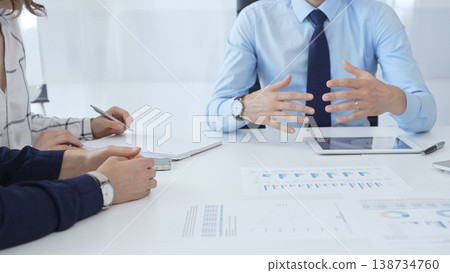 Business people reviewing financial metrics on digital screens, collaborating strategically while examining charts and graphs in office 138734760