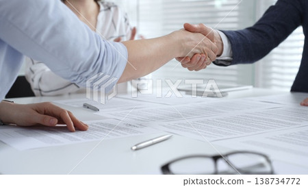 Business executives shaking hands, sealing an agreement after successful negotiations in a bright office, symbolizing partnership, collaboration, and a mutually beneficial deal signing Business executives shaking hands, sealing an agreement after successful negotiations in a bright office, symbolizing partnership, collaboration, and a mutually beneficial deal signing 138734772