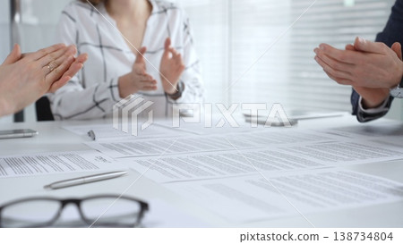Business executives shaking hands, sealing an agreement after successful negotiations in a bright office, symbolizing partnership, collaboration, and a mutually beneficial deal signing 138734804