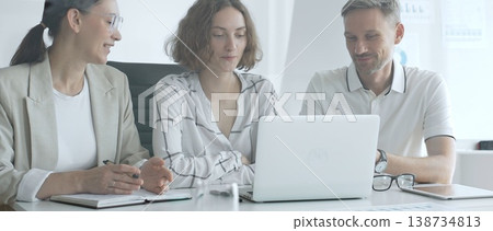 Business professionals reviewing marketing analytics on laptops, working together strategically in contemporary workplace with minimalist interior design and collaborative atmosphere Business professionals reviewing marketing analytics on laptops, working together strategically in contemporary workplace with minimalist interior design and collaborative atmosphere 138734813