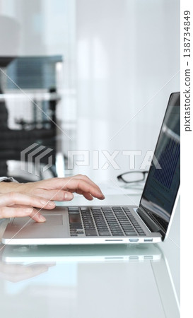 Hands expertly typing on a laptop keyboard, a professional working on important business tasks and digital communication in a modern, clean office environment Hands expertly typing on a laptop keyboard, a professional working on important business tasks and digital communication in a modern, clean office environment 138734849