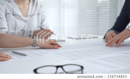 Business executives shaking hands, sealing an agreement after successful negotiations in a bright office, symbolizing partnership, collaboration, and a mutually beneficial deal signing 138734853