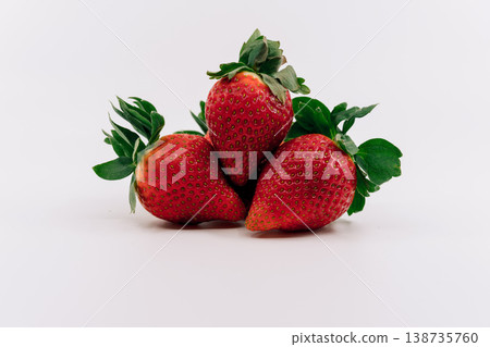 Three fresh, juicy strawberries placed on a white background. Three fresh, juicy strawberries placed on a white background. 138735760