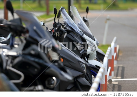 Image of motorcycles lined up in a bicycle parking area. Image of motorcycles lined up in a bicycle parking area. 138736553