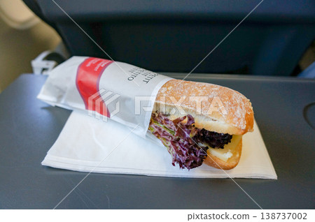 用紙袋包裹的法國麵包三明治的一角，作為機上餐點提供。 138737002