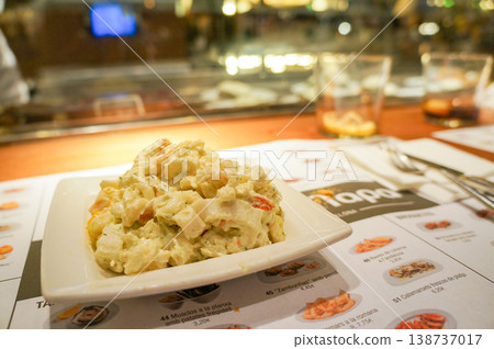 Enjoying tapas at a stylish restaurant in Barcelona: a delightful counter lunch experience. Enjoying tapas at a stylish restaurant in Barcelona: a delightful counter lunch experience. 138737017