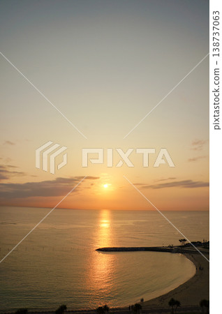 海景展現了蜿蜒的沙灘和被夕陽染成橘色的天空。 138737063