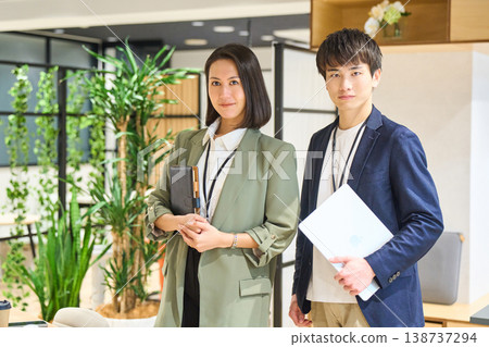 年輕男女在綠樹成蔭的辦公室裡笑容燦爛。 年輕男女在綠樹成蔭的辦公室裡笑容燦爛。 138737294