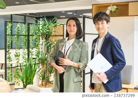 年輕男女在綠樹成蔭的辦公室裡笑容燦爛。 138737299