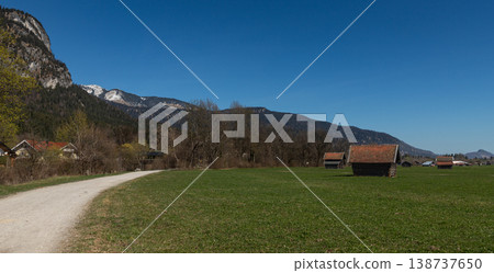 Curving Gravel Path and Rustic Huts in Bavarian Meadow 138737650