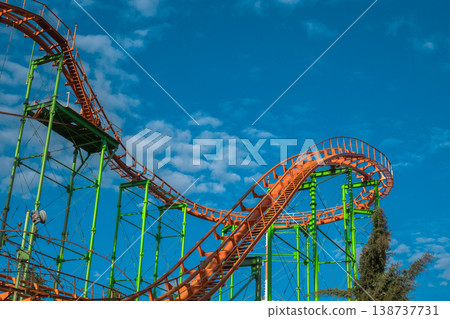 Abstract detail of empty orange roller coaster loops against a bright blue sky 138737731