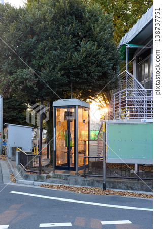 A telephone booth illuminated by the setting sun. A telephone booth illuminated by the setting sun. 138737751