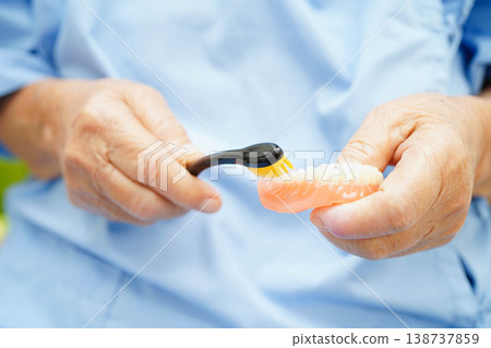 Doctor clean teeth denture with toothbrush for teach patient and dentist studying about dentistry. Doctor clean teeth denture with toothbrush for teach patient and dentist studying about dentistry. 138737859