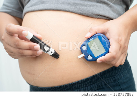 Asian woman injecting herself diabetes injecting insulin in stomach at home. Asian woman injecting herself diabetes injecting insulin in stomach at home. 138737892