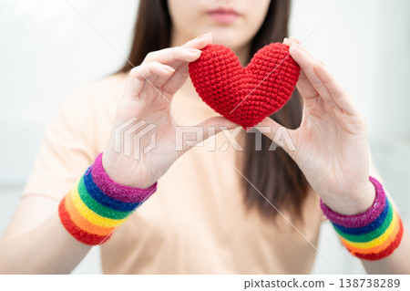 Asian woman holding LGBT heart with rainbow flag. 138738289