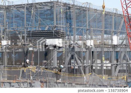 十名工人在建築工地引導起重機吊起的地板材料進行著陸作業。 138738904