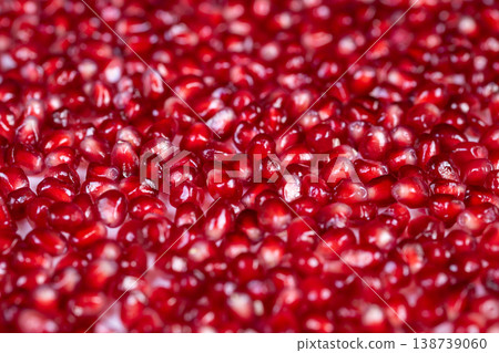 Vivid fruit imagery. Colorful pomegranate seeds closeup. Fresh juicy arils glowing under natural light. Brightly lit image of vibrant pomegranate seeds and health benefits 138739060