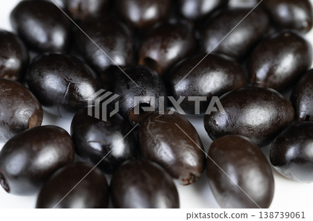 Black olives showcased. Closeup of mixed black olives for images. Arrangement of assorted black olives captured closely for culinary presentation and advertising needs Black olives showcased. Closeup of mixed black olives for images. Arrangement of assorted black olives captured closely for culinary presentation and advertising needs 138739061