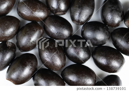 Detail shot of shining olives. Macro image highlighting olive surface texture and glossiness. Highcontrast closeup revealing olive skin shine and moisture details Detail shot of shining olives. Macro image highlighting olive surface texture and glossiness. Highcontrast closeup revealing olive skin shine and moisture details 138739101