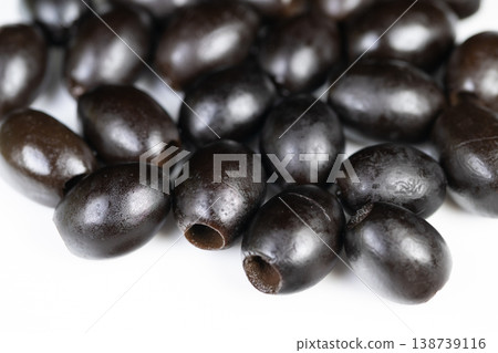 Heaped black olives suggesting market vendor display, assorted sizes with natural sheen, rustic texture and subtle pits, evokes organic harvest and snack culture 138739116